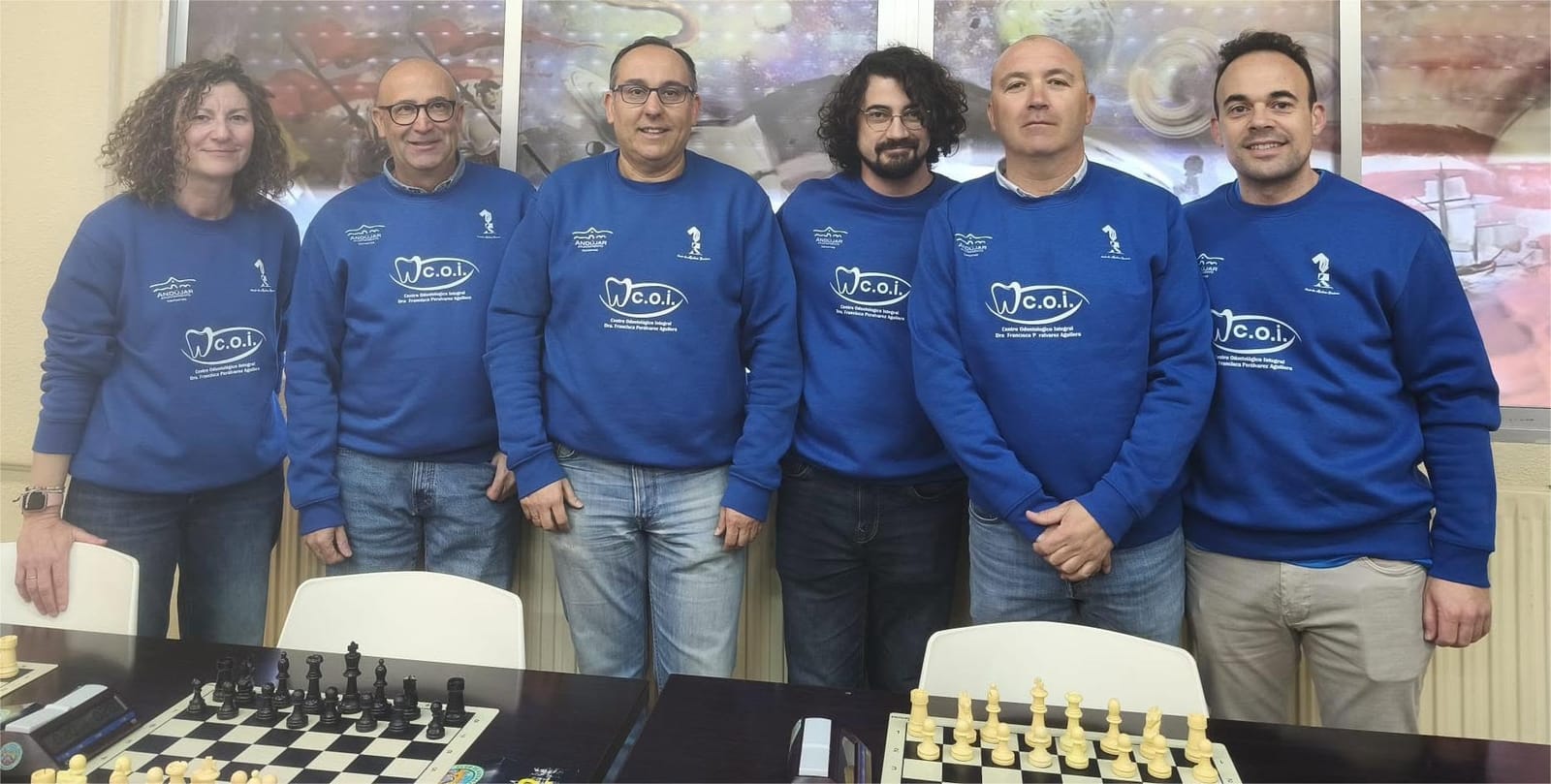 Profesorado responsable del Aula de Jaque, con la equipación del Club de Ajedrez Jándula, junto a los tableros de juego